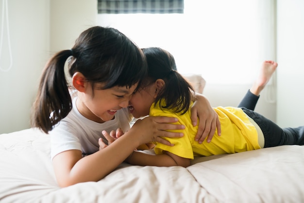 Cute asian children lying on the bed