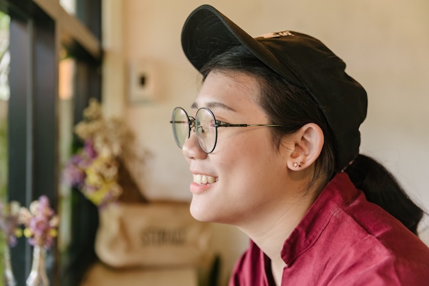 Cute Asian fat teen smile with glasses smiling and looking out of windows