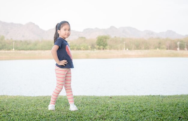 cute asian girl exercise on green grass