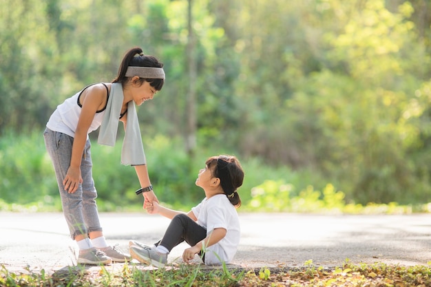 Cute asian girl give hand to help sister accident during running