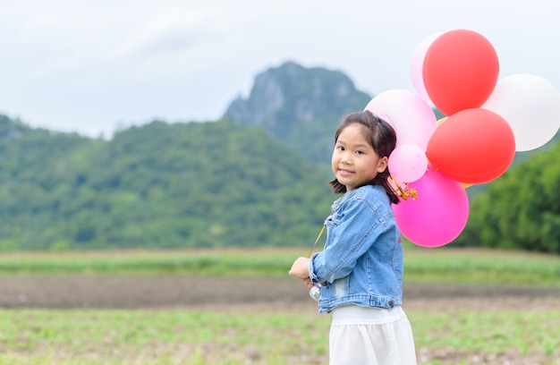 かわいいアジアの女の子の笑顔と風船