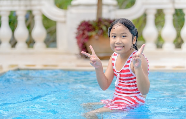 Cute asian girl smile in swimming pool, recreation and leisure concept