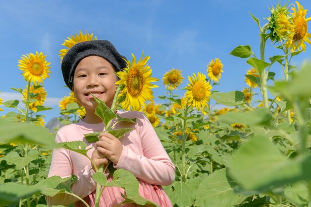 ひまわりの花とかわいいアジアの女の子笑顔