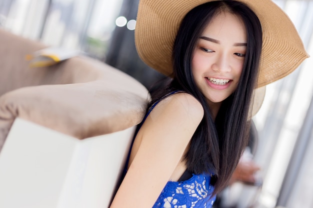 cute asian gril with summer dress and hat with relaxing pose with white room background