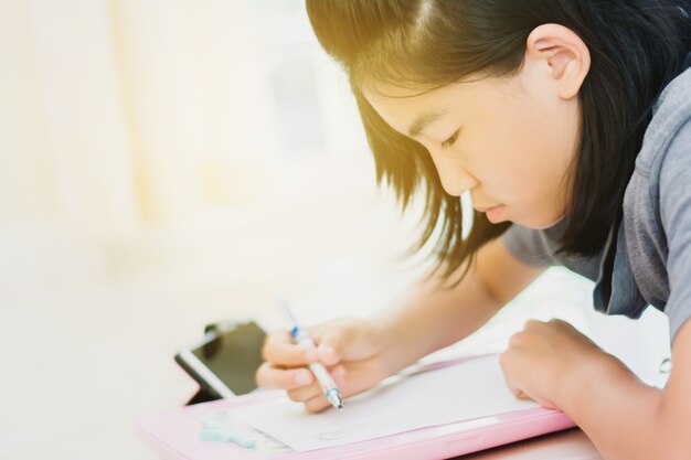 Cute Asian kids drawing cartoon at home in morning