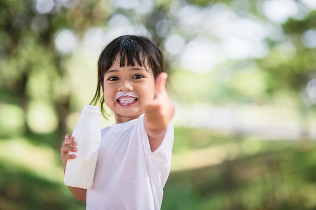 かわいいアジアの小さな子供の女の子は、ミルク、ソフトフォーカスを飲んでいます