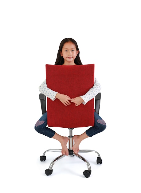 Cute Asian little girl child straddling a red chair with looking at camera on white.