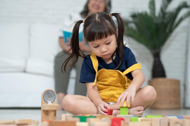 Cute asian little girl playing with colorful toy blocks Kids play with educational toys