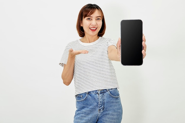 귀여운 아시아 짧은 갈색머리 여성은 스마트폰 앱 여성 블로거가 개인 소셜 미디어 페이지를 보여주는 스마트폰 앱을 홍보하고 흰색 배경에서 행복하게 웃는 카메라를 들고 있습니다.