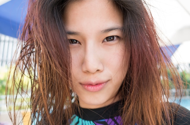 Cute Asian surfer Girl with messy hair on the beach