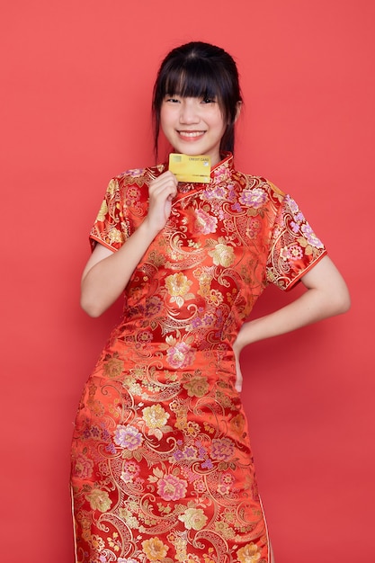 写真 カードと伝統的なドレスのかわいいアジアの女性