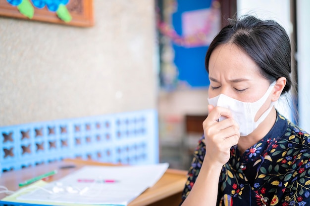 Cute Asian woman She wears a PM25 dust mask that is a big problem in Thailand She has a serious illness and cough