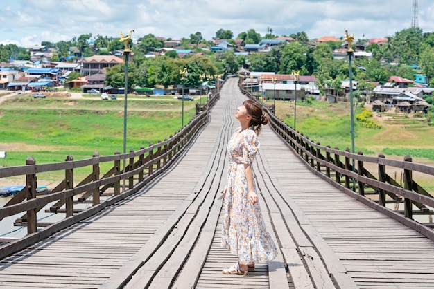 Cute asian woman wear casual posting alone on wooden bridge at Sangkhaburi, Kanchanaburi, Thailand.