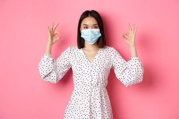 Cute Asian woman wearing medical mask and dress