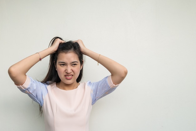 Cute asian woman on white wall background