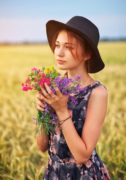 Cute attractive girl with a bouquet of colorful flowers in her hands