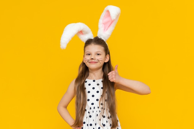 Cute attractive girl with Easter bunny ears gave a thumbs up Easter day and egg coloring