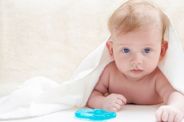 Cute baby after bath in towel on a light background Copyspace