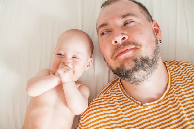 Carino bambino sulle braccia del suo grande papà forte.