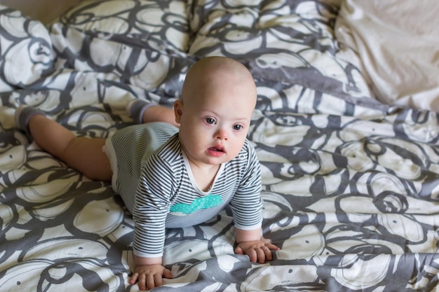 Cute baby boy lying on bed at home