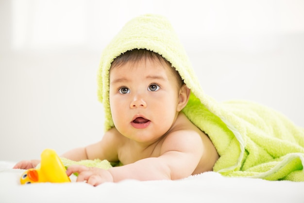 Cute baby boy lying under a towel