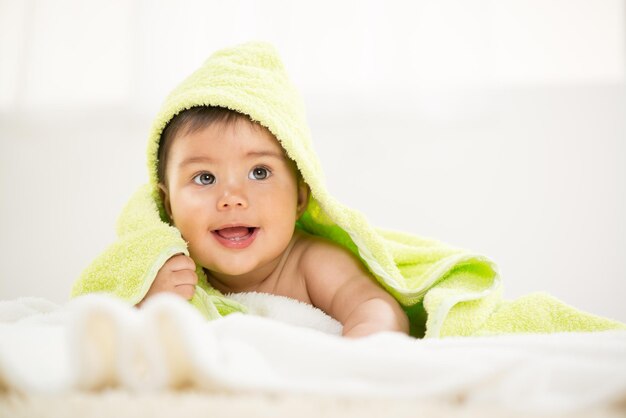 Cute baby boy lying under a towel