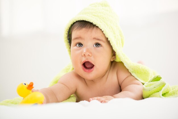 Cute baby boy lying under a towel