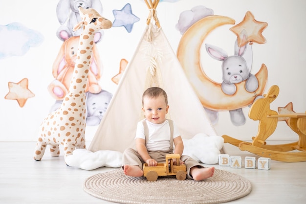 Cute baby boy playing with wooden natural toys in the children's room at home educational toys for children