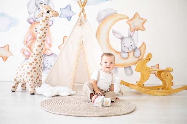 Cute baby boy playing with wooden natural toys in the children's room at home educational toys for children