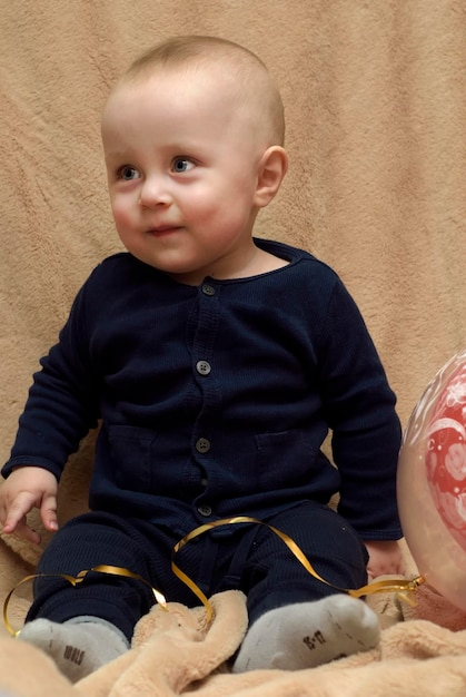 Cute baby boy sitting on bed