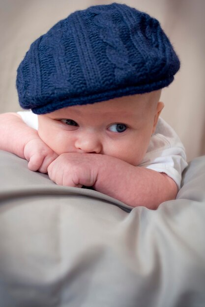 Foto un bambino carino con una coperta che guarda da un'altra parte.