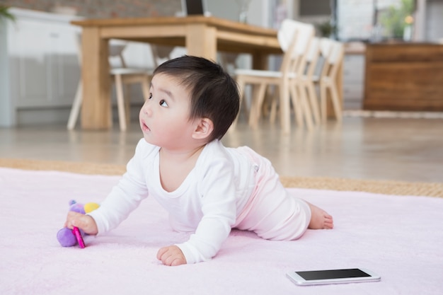 見上げるカーペットの上のかわいい赤ちゃん