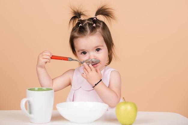 かわいい赤ちゃんの子供は食べ物を食べる赤ちゃんは健康的な食べ物を食べる子供の女の子を食べる