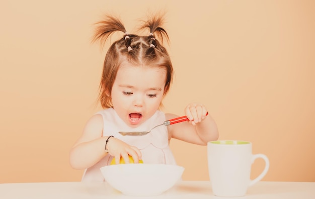 귀여운 아기 아이가 음식을 먹습니다. 먹는 아기 과일 퓌레를 먹는 작은 아기