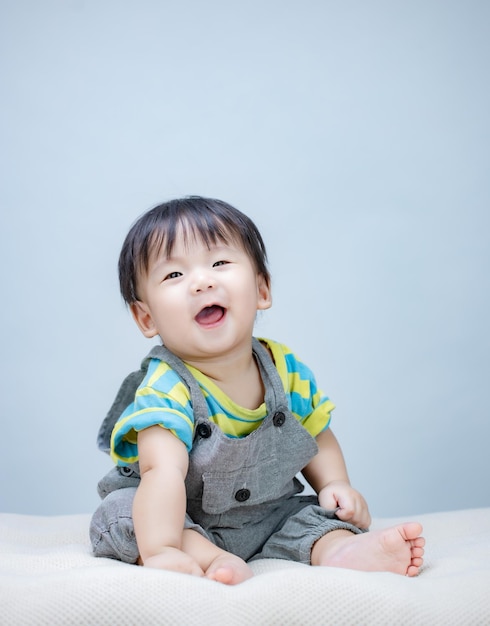 귀여운 아기 아이 침대에 앉아