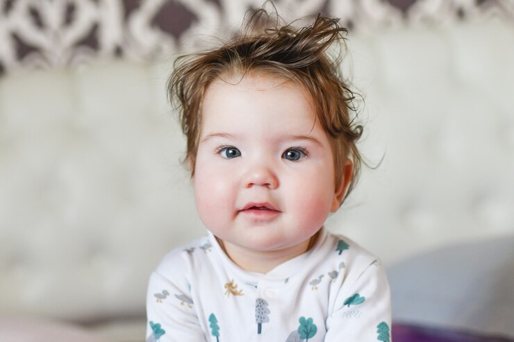 Cute baby, close up. Portrait of a crawling baby on the bed in her room.