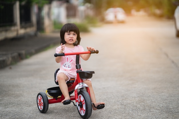 泣いて自転車に乗るかわいい赤ちゃん