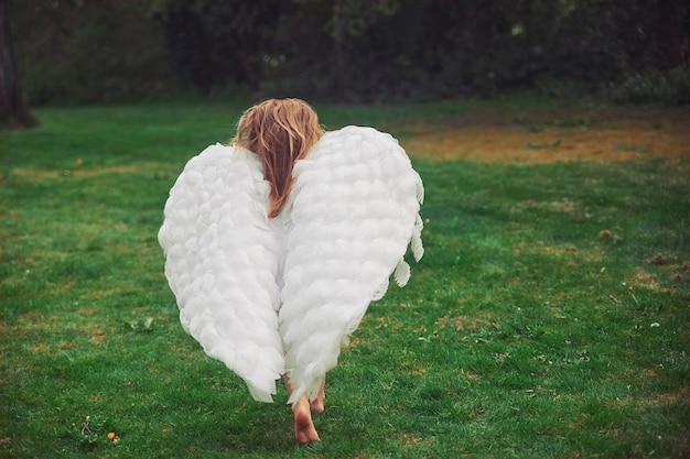 덴마크의 저녁 숲에서 천사처럼 옷을 입은 귀여운 아기
