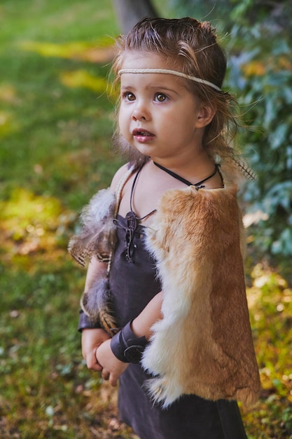 Cute baby dressed in the clothes of primitive people