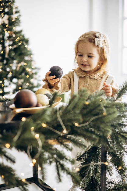 Cute baby girl by the christmas tree