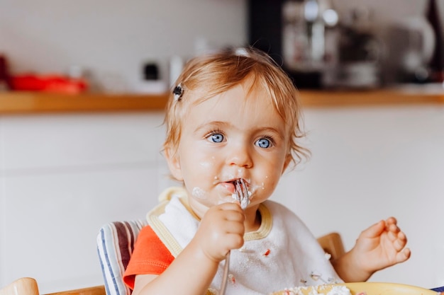 cute baby girl eating food at home