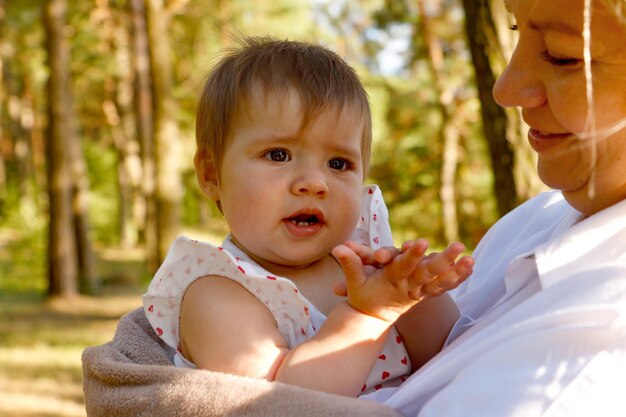 cute baby girl in her mothers arms in the park