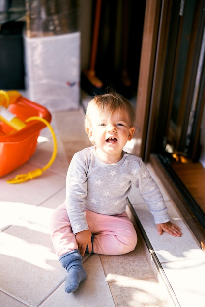 Photo cute baby girl sitting on floor at home