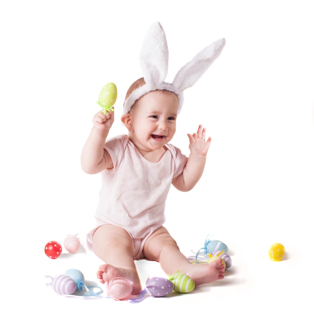 흰색 절연 니트 토끼 모자에 앉아 귀여운 아기 소녀
