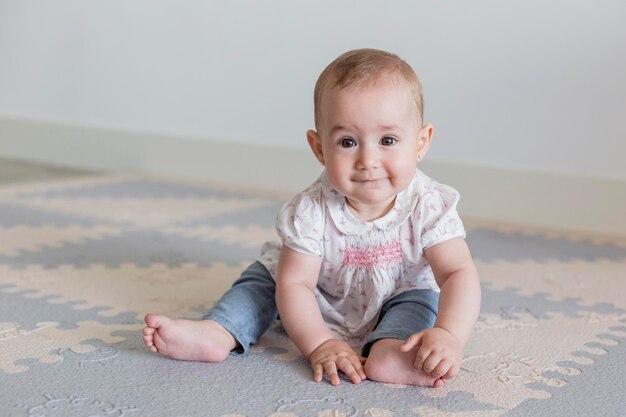 Photo cute baby girl sitting on mat