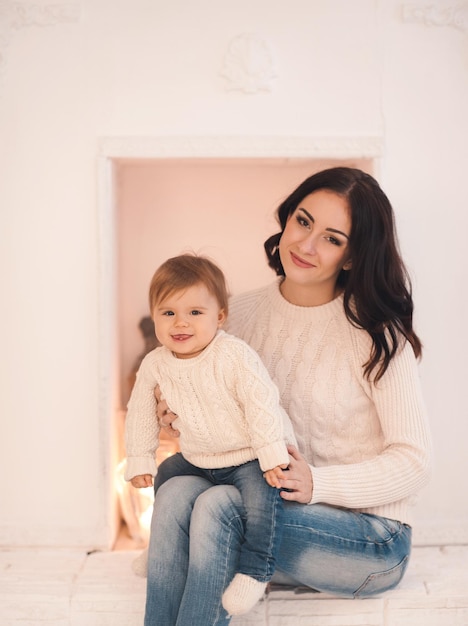 Cute baby girl under sitting on mothers knees