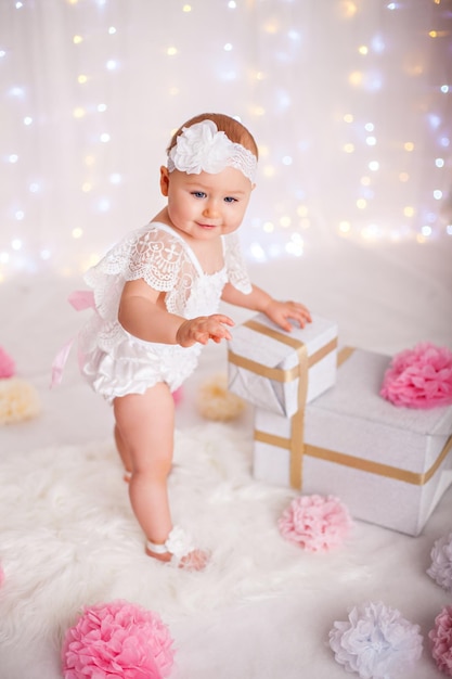 Bambina carina che soggiorna tra un sacco di scatole regalo per festeggiare il compleanno o il natale