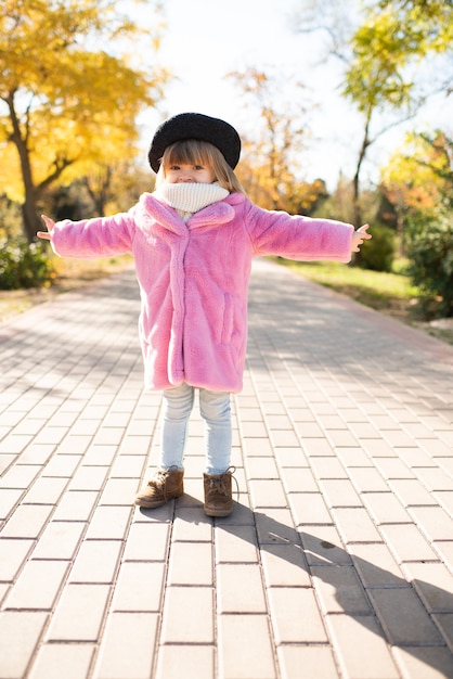 写真 ふわふわのピンクのコートと帽子を身に着けているかわいい女の赤ちゃん