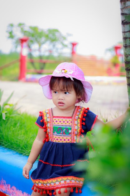 Cute baby girl wearing hat in park