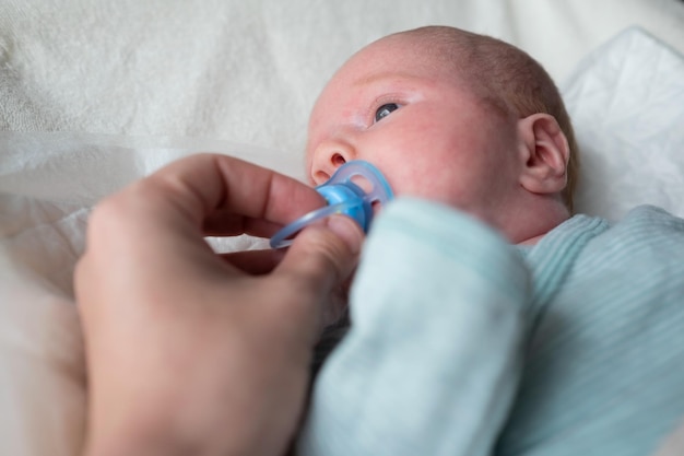 Cute baby girl with a soother or pacifier in her mouth